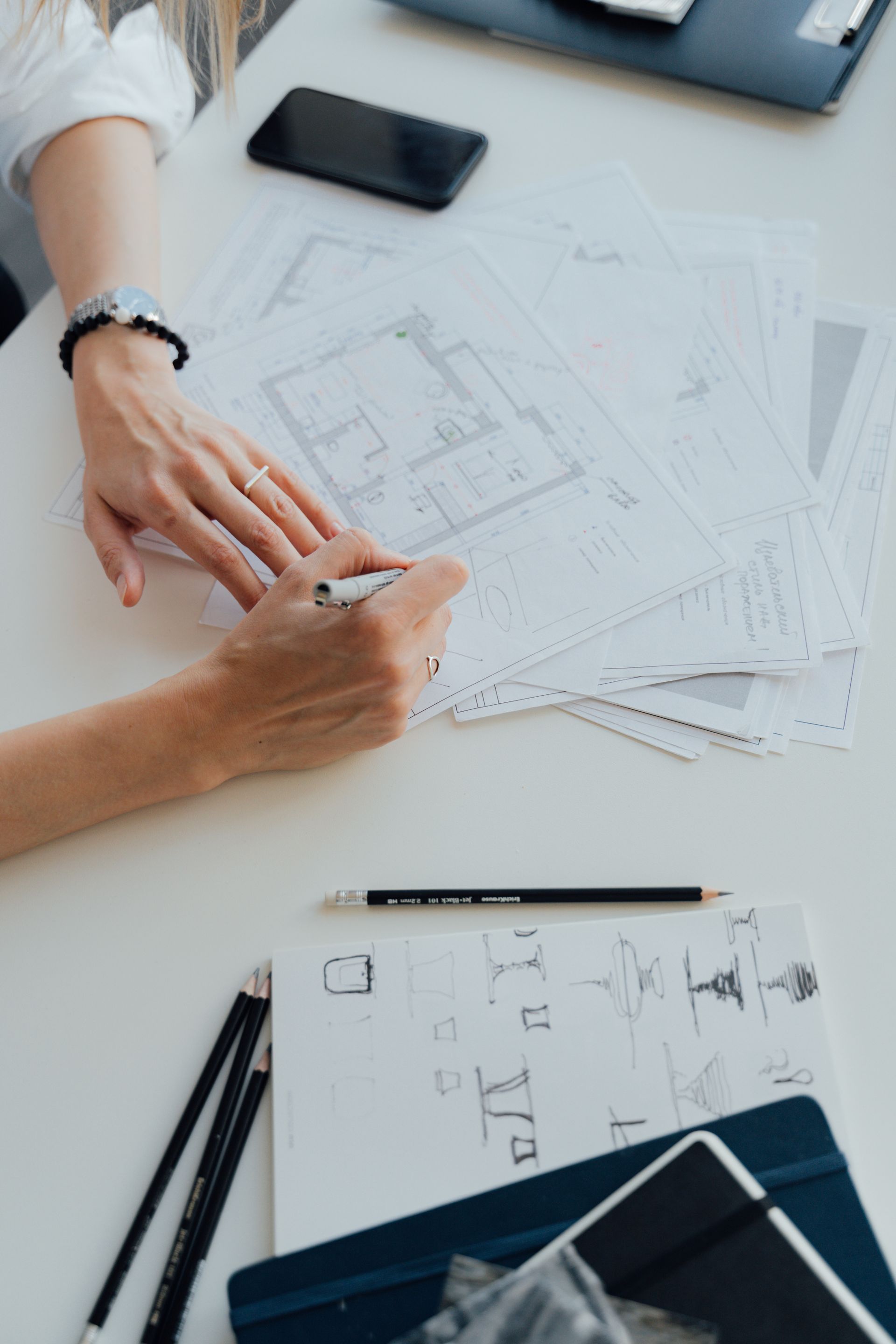 Manos de arquitecta revisando planos sobre la mesa